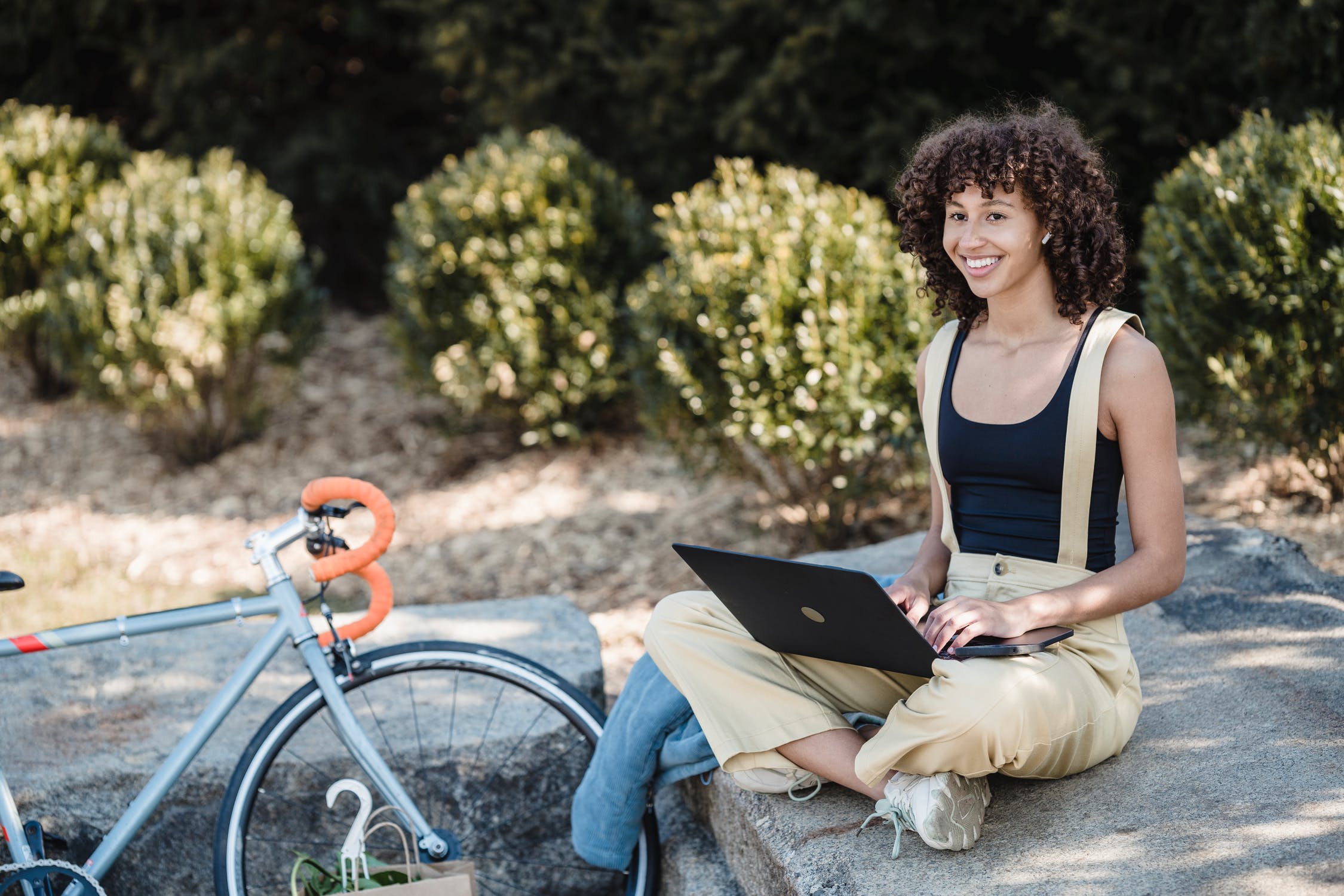 Black woman outdoors on laptop