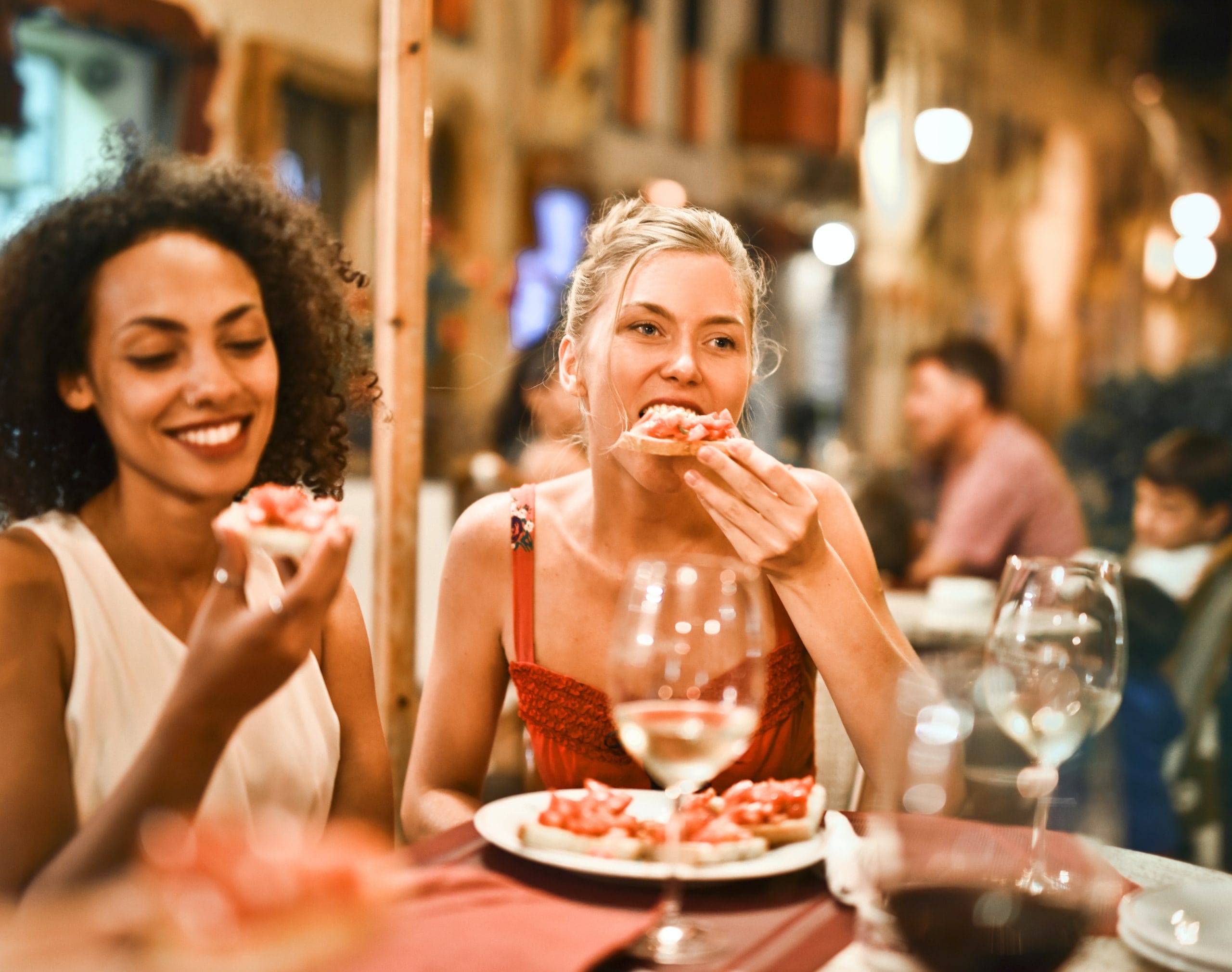 black woman eating at resteraunt socially with friend