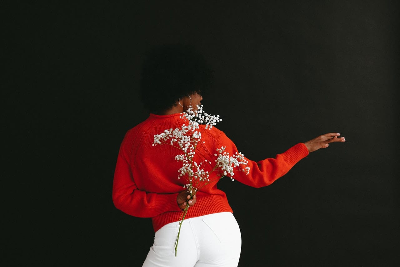 a black woman dancing and holding flowers
